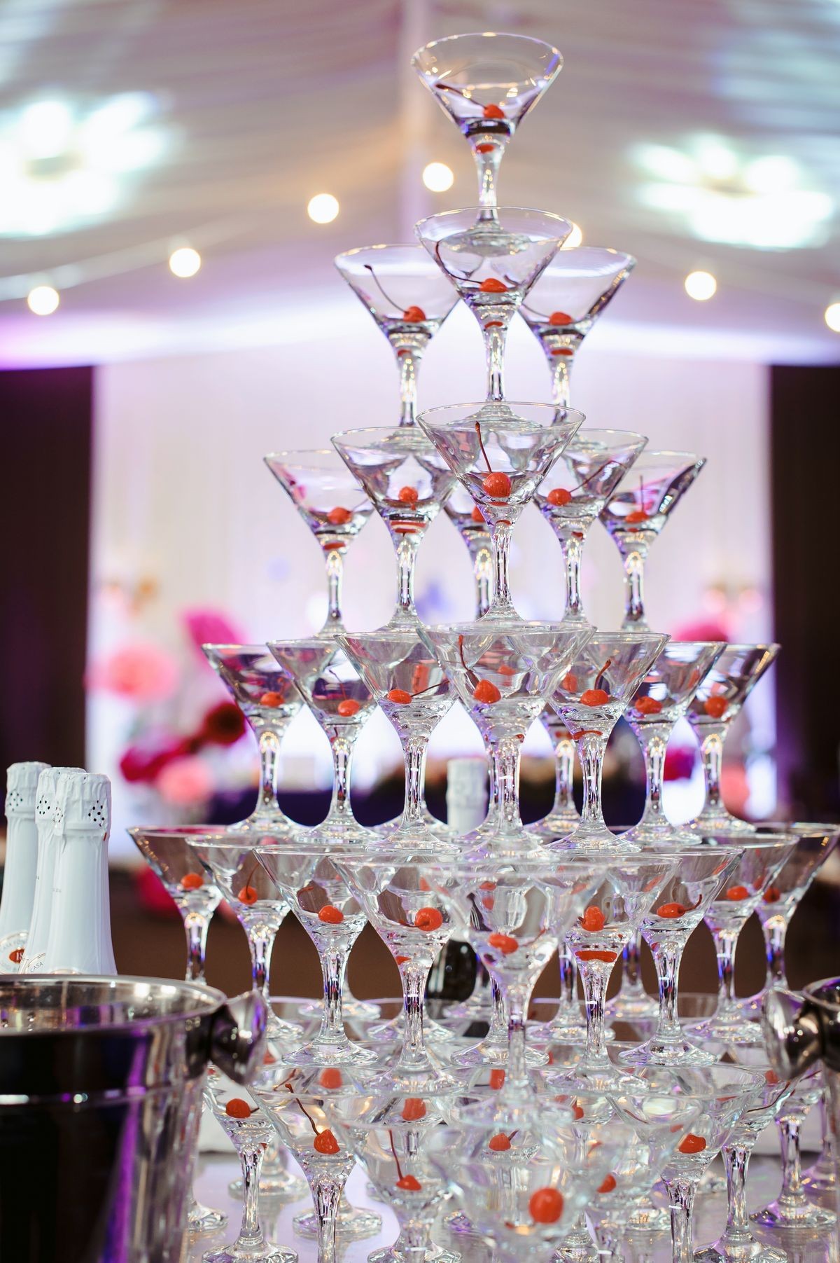 Champagne slide. Pyramid or fountain made of champagne glasses with cherry and steam from dry ice. Wedding party catering wine glasses. Event planner concept